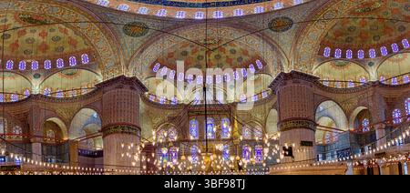 Intérieur de la Mosquée bleue, Istanbul, Turquie. L'intérieur de la Mosquée bleue (Mosquée du Sultan Ahmed) à Istanbul est réputé pour ses caractéristiques architecturales étonnantes. Construit au début du XVIIe siècle, il est célèbre pour son vaste dôme, entouré de petits dômes et semi-dômes, créant un sentiment de grandeur. L'intérieur de la mosquée est orné de plus de 20 000 carreaux de céramique faits à la main en bleu et blanc, ainsi que de calligraphies complexes et de vitraux. Il sert à la fois de lieu de culte et d'attraction touristique majeure, reflétant la grandeur de l'architecture ottomane. Banque D'Images