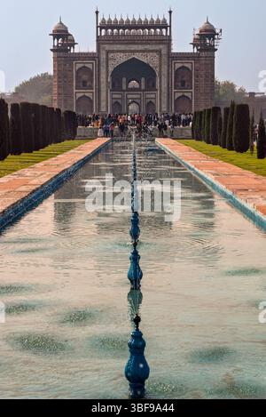 Porte d'entrée du Taj Mahal, Agra, Inde. La porte d'entrée du Taj Mahal, connue sous le nom de Grande porte ou Darwaza-i-Rauza, est la grande porte principale vers le mausolée emblématique d'Agra, en Inde. Construit en grès rouge avec incrustation de marbre blanc complexe, il a été achevé vers 1648. La porte présente des inscriptions coraniques et des motifs floraux, reflétant l'élégance architecturale moghole. Il joue un rôle à la fois cérémoniel et symbolique, préparant les visiteurs à la splendeur du Taj Mahal au-delà. Banque D'Images