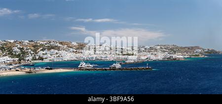 Port de Mykonos, Mykonos, Grèce le port de Mykonos, situé au cœur de la ville de Mykonos, est un port animé connu pour son mélange de bateaux de pêche traditionnels et de yachts de luxe. Le port est entouré de bâtiments blanchis à la chaux, de cafés et de boutiques, offrant une vue imprenable sur la mer Égée. Historiquement, elle a servi de port important pour le commerce et la navigation, et aujourd'hui, elle reste un point d'arrivée populaire pour les visiteurs explorant les charmantes rues et les plages de l'île. Banque D'Images