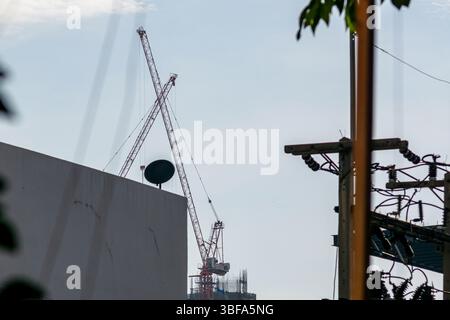 Une vue de grues surplombant un chantier urbain, mettant en valeur le développement urbain et l'activité industrielle dans un environnement animé. Banque D'Images