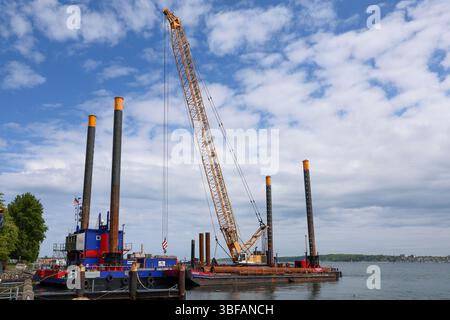 Kiel, Allemagne - 28. Mai 2025 : grue opérant sur une barge, effectuant des travaux de construction offshore à Kiel, Allemagne Banque D'Images