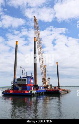 Kiel, Allemagne - 28. Mai 2025 : grue pose les fondations des éoliennes offshore dans le fjord de Kiel Banque D'Images