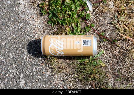 Kiel, Allemagne - 28. Mai 2025 : canette de Coca-Cola jetée sur le bord de la route, illustrant la pollution de l'environnement et l'élimination négligente des déchets Banque D'Images