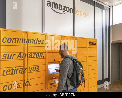 Homme utilisant Amazon Locker dans le centre commercial, point de ramassage orange pour les marchandises par correspondance avec le logo de la marque Amazon. Photographie mobile. Lyon, France - F Banque D'Images