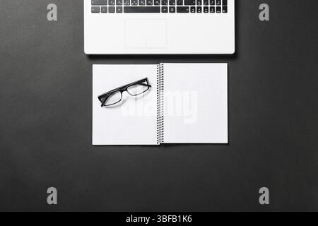Nature morte du lieu de travail de bureau avec fournitures et espace de copie. Surface noire plane avec ordinateur portable et ordinateur portable vierge ouvert. Paperasse, audit et Banque D'Images