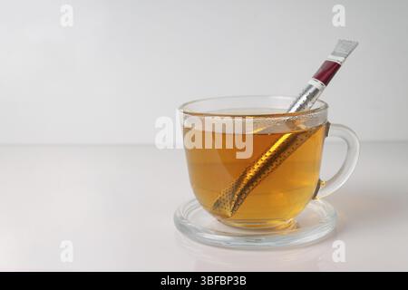Collez le sachet de thé, dans une tasse en verre transparent, maquette, espace de copie Banque D'Images