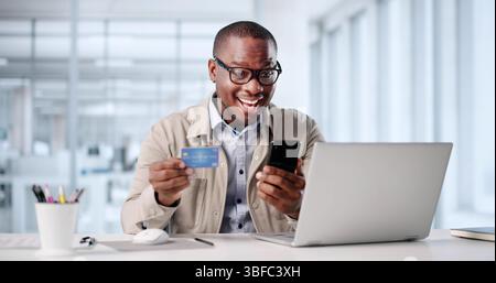 Homme afro-américain payant heureux pour les achats en ligne avec carte de crédit. Banque D'Images