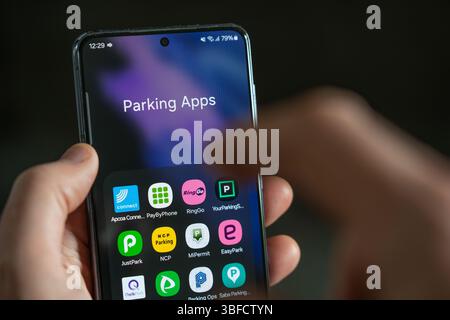 Homme sélectionnant une application de stationnement sur un écran de smartphone, Royaume-Uni. Il existe actuellement des propositions visant à remplacer les applications par une plate-forme nationale de stationnement Banque D'Images