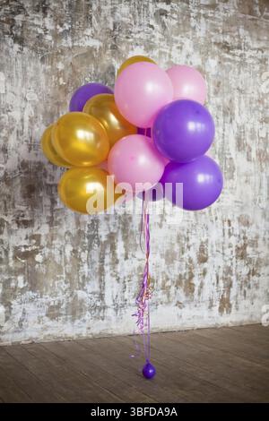 Bouquet de ballons lumineux contre un mur texturé. Copy space Banque D'Images