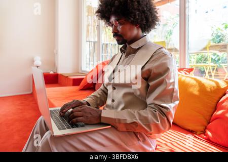 Homme d'affaires noir travaillant dans un bureau d'entreprise de coworking - jeune homme noir portant des vêtements décontractés d'affaires fonctionne dans une technologie de démarrage créative Banque D'Images