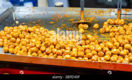 Boulettes de viande épicées sur une poêle plate. Cuisine de rue indonésienne Banque D'Images
