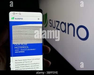 Stuttgart, Allemagne - 01-20-2025 : personne tenant un smartphone avec la page web de la société brésilienne de pâte et papier Suzano S.A. sur l'écran avec le logo. Banque D'Images