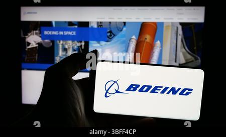Stuttgart, Allemagne - 01-16-2025 : personne tenant un téléphone portable avec le logo de l'entreprise aérospatiale américaine The Boeing Company sur l'écran Banque D'Images