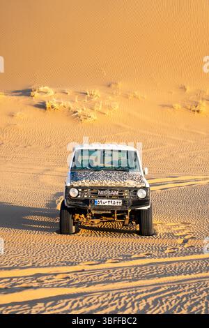 Kashan, Iran - 12 novembre 2023 : VUS Nissan blanc garé sur le sable dans le désert iranien Banque D'Images