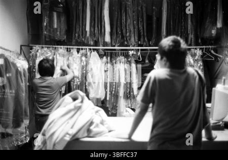 Fin des années 2000 Hangzhou magasin de nettoyage à sec avec le personnel de tri des vêtements, Zhejiang, Chine Banque D'Images