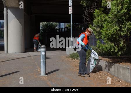Portland, Oregon - 17 août 2017 : des bénévoles nettoient les ordures dans un espace public, portent des gilets de sécurité et utilisent des ramasseurs de déchets. Banque D'Images
