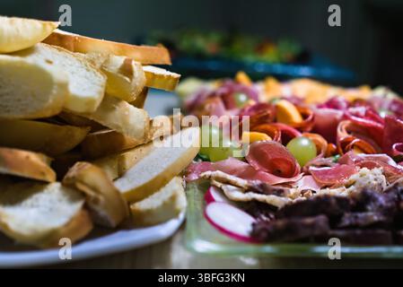 ​​bread tranchés et charcuterie avec assortiment de viandes, fromages, raisins et radis Banque D'Images