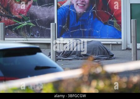 LES RÉDACTEURS NOTENT LE CONTENU enveloppes de coquillages à côté d'une couverture couvrant un corps sur la scène au Fairgreen Shopping Centre, Carlow, où un homme est soupçonné d'être mort suite à un incident de fusillade. L'agence de presse PA comprend que les blessures de l'homme mort ont été auto-infligées. Date de la photo : dimanche 1er juin 2025. Banque D'Images