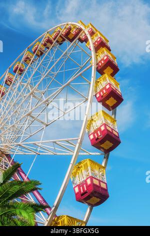 Sous une grande roue et des gondoles contre un ciel bleu nuageux Banque D'Images