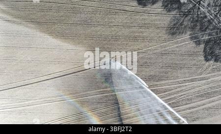 Vue aérienne de drone du système d'irrigation, arroseurs de pistolets de pluie à jet d'eau sur le terrain, paysage de scène rurale le jour ensoleillé, fond de champ Banque D'Images