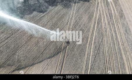 Vue aérienne de drone du système d'irrigation, arroseurs de pistolets de pluie à jet d'eau sur le terrain, paysage de scène rurale le jour ensoleillé, fond de champ Banque D'Images