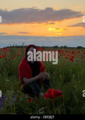 Jeune femme dans Poppy Field avec Red Hat Banque D'Images