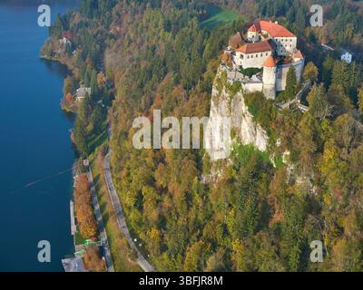 VUE AÉRIENNE. Château de Bled (Blejski grad) perché sur une falaise surplombant le lac de Bled. Bled, haute Carniole, Slovénie. Banque D'Images