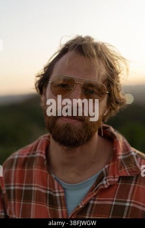 Portrait d'un homme barbu aux cheveux roux en lunettes de soleil Banque D'Images