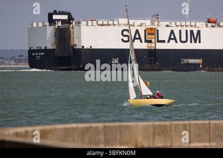 Cowes, île de Wight, Royaume-Uni. 1er juin 2025. Un yacht classique passe devant la LUNE D'ARGENT du navire ro-ro lors des événements de régate Cowes Classic au large de Cowes, île de Wight, Royaume-Uni. 2 juin 2025. Crédit : Will Beresford/Alamy Live News Banque D'Images