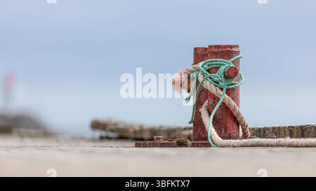 Borne en métal rouillé sur la jetée en bois avec fond flou sur la côte norvégienne Banque D'Images