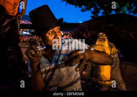 Un toxicomane colombien ressent le premier coup en fumant du basuco – une pâte de cocaïne sale et non raffinée – dans une rue d’El Bronx, Medellín, Colombie. Banque D'Images