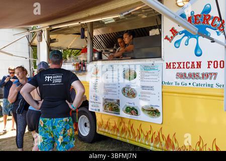 The Big Float, Portland, Oregon - 15 juillet 2017 : les gens font la queue au camion alimentaire mexicain la Merced pour commander de la nourriture aux deux femmes qui travaillent à l'intérieur. Banque D'Images