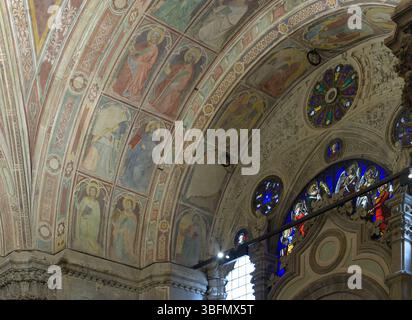 Voûtes peintes avec des fresques de saints et des panneaux géométriques, à côté de vitraux et de roses à Orsanmichele, Florence, Italie. Banque D'Images