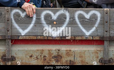 Trois cœurs blancs et une main humaine sur remorque en bois. Gros plan, perspective. Touchez l'amour. Concept Banque D'Images