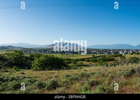 Santaquin, Utah – 2 juin 2025 : vue panoramique sur un quartier résidentiel avec un fond montagneux et une vallée ouverte sous un ciel dégagé. Banque D'Images