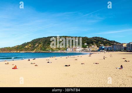 Les gens appréciant une journée ensoleillée ay Zurriola Beach, San Sebastian, Espagne Banque D'Images