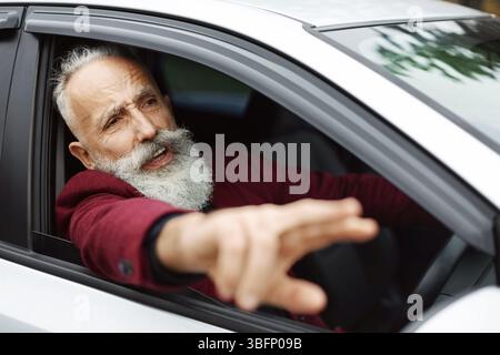 Homme nerveux conducteur combattant sur la route, coincé dans la circulation Banque D'Images