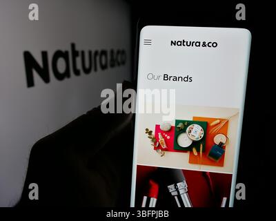 Stuttgart, Allemagne - 01-23-2025 : personne tenant un smartphone avec la page web de la société brésilienne de cosmétiques Natura Co Holding S.A. sur l'écran avec le logo. Banque D'Images