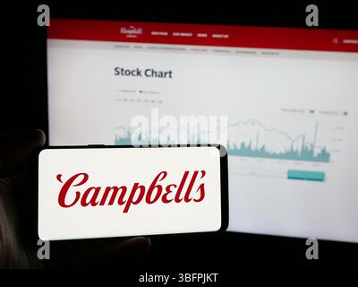Stuttgart, Allemagne - 01-23-2025 : personne tenant un smartphone avec le logo de l'entreprise américaine de transformation des aliments The Campbell's Company sur l'écran Banque D'Images
