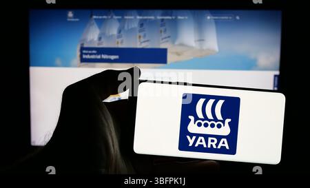 Stuttgart, Allemagne - 01-23-2025 : personne tenant un smartphone avec le logo de la société chimique norvégienne Yara International ASA sur l'écran Banque D'Images
