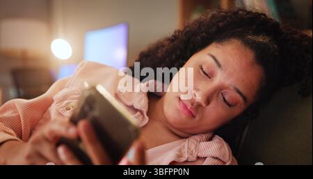Fille, téléphone et triste sur le canapé avec SMS, contact et chat de saisie avec l'application mobile dans le salon. Femme, smartphone et notification pour rupture Banque D'Images