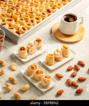 Assortiment de desserts arabes ottomans avec des rouleaux de noix mélangés (amande, pistache, noix de cajou), servis avec du café sur fond blanc Banque D'Images
