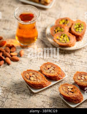 Assortiment de rouleaux de noix avec kunafa aux amandes, pâtisseries sucrées en couches, desserts arabes traditionnels 2 Banque D'Images