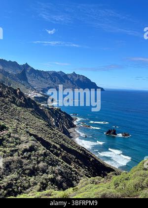 Côte spectaculaire du nord de Tenerife avec des eaux bleu profond de l'Atlantique et des crêtes acérées des montagnes Anaga sous un ciel clair. Banque D'Images