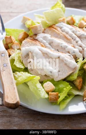 Salade César croquante avec poulet sur table en bois Banque D'Images
