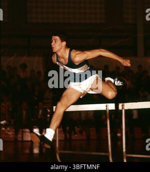 Photographie prise par A.V. Shirk d'un événement d'athlétisme au lycée de Worthington vers 1955, montrant un athlète en saut à mi-hauteur des haies. Banque D'Images