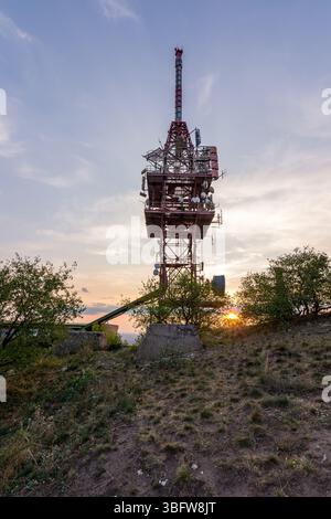 Antenne de tour d'émetteur pendant le coucher du soleil sur une petite colline. Banque D'Images