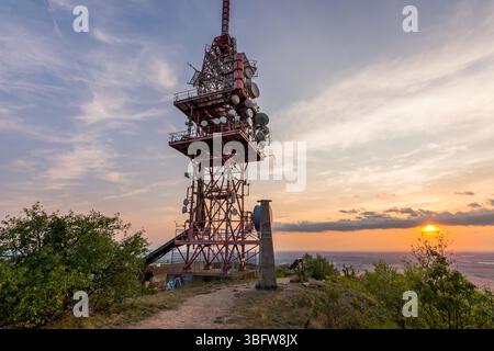 Antenne de tour d'émetteur pendant le coucher du soleil sur une petite colline. Banque D'Images