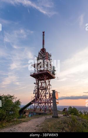 Antenne de tour d'émetteur pendant le coucher du soleil sur une petite colline. Banque D'Images
