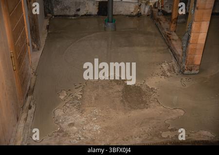Plancher de béton humide à l'intérieur de la structure en bois pendant la construction ou la rénovation plancher de béton humide à l'intérieur de la structure en bois pendant la construction ou renova Banque D'Images
